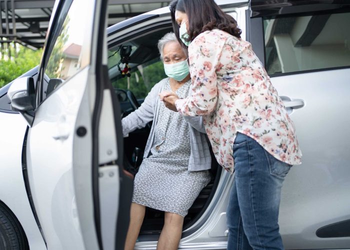 Help and support asian senior or elderly old lady woman patient sitting on wheelchair prepare get to her car, healthy strong medical concept.